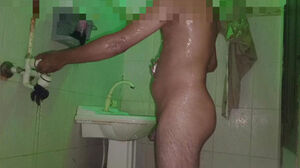 A fellow alone having tub in washroom with a juggling backside
