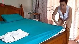 Nudist housekeeper Regina Noir makes the bedding in the bedroom. Naked maid. Naked housewife. 2