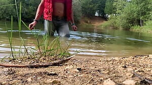 Trans-girl swimming in denim and pinkish top in the lake..