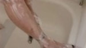 Plus-size Wendi soaps gams and soles in bathroom